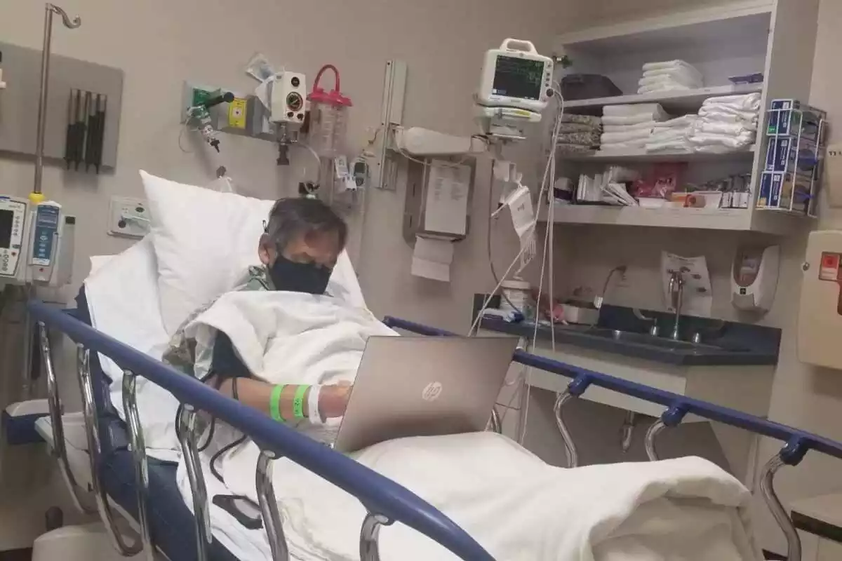 Alejandro en su cama de hospital con su portátil