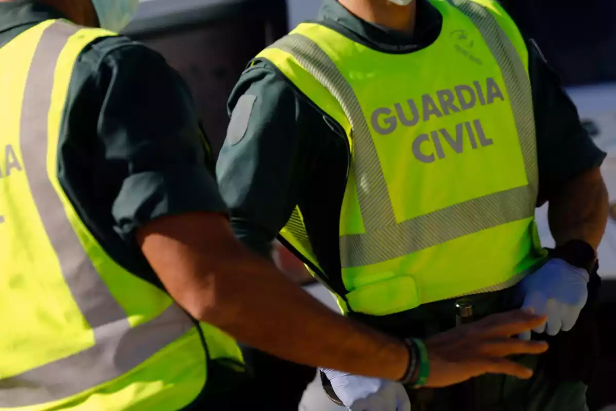 Dos agentes de la Guardia Civil hablan con un pasajero durante un control de movilidad en Alguazas, Murcia (España)