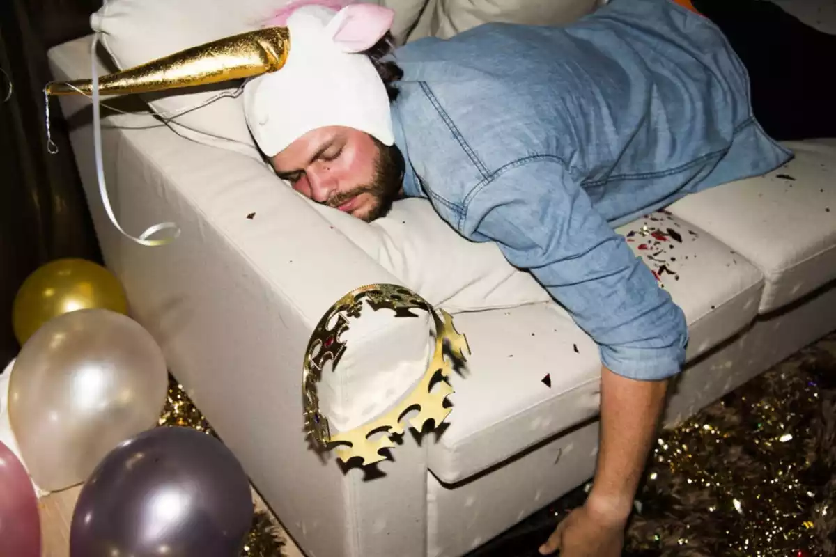 Hombre tumbado en el sofá después de una fiesta