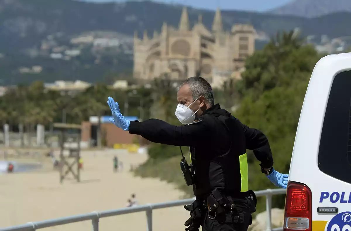 Policia con mascarilla en la playa
