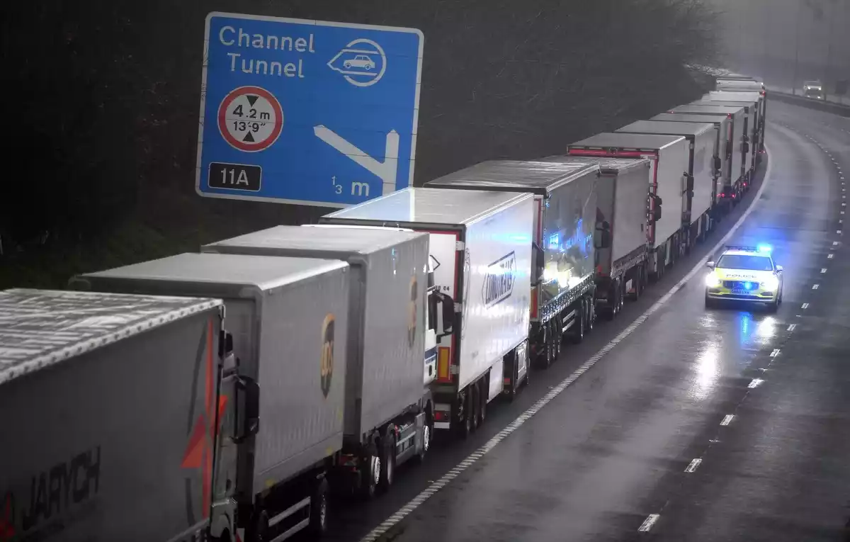 Un coche de policía pasa junto a una larga cola de camiones que permanecen atrapados a causa del cierre de la frontera con Reino Unido