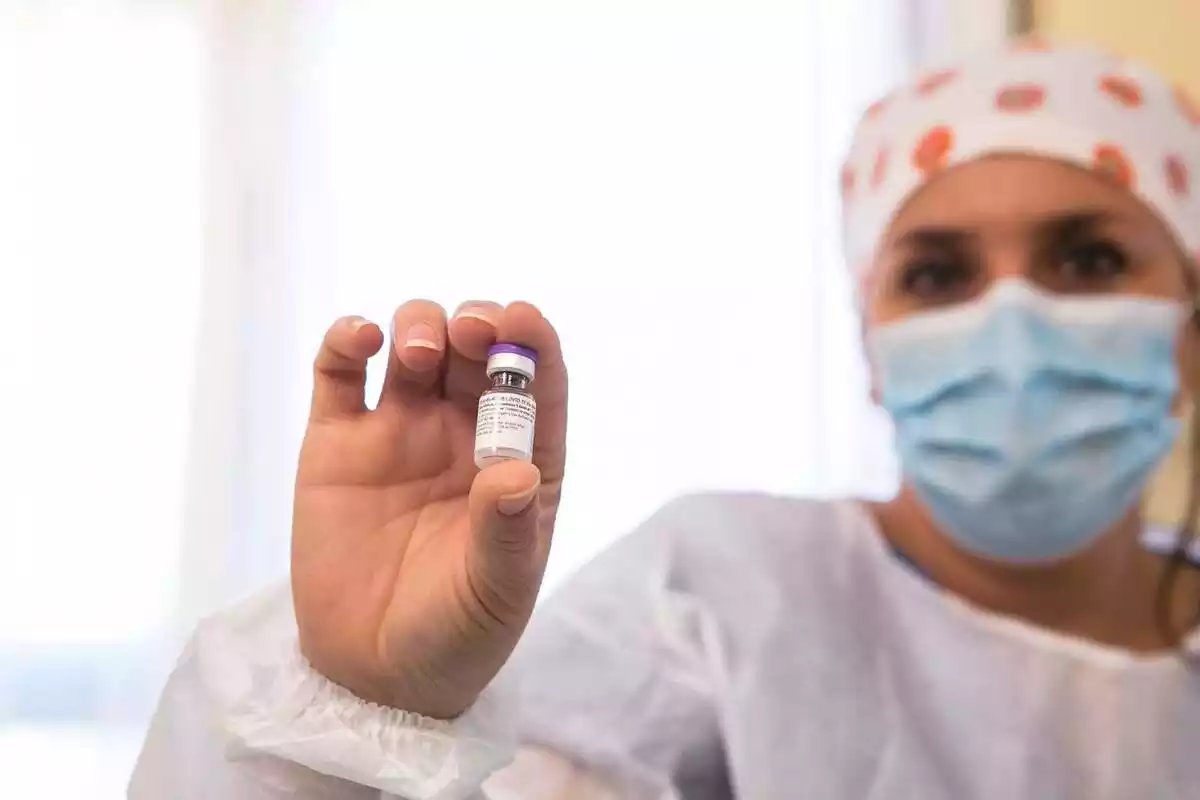Una sanitaria muestra una dosis de la vacuna de Pfizer que sostiene en la mano