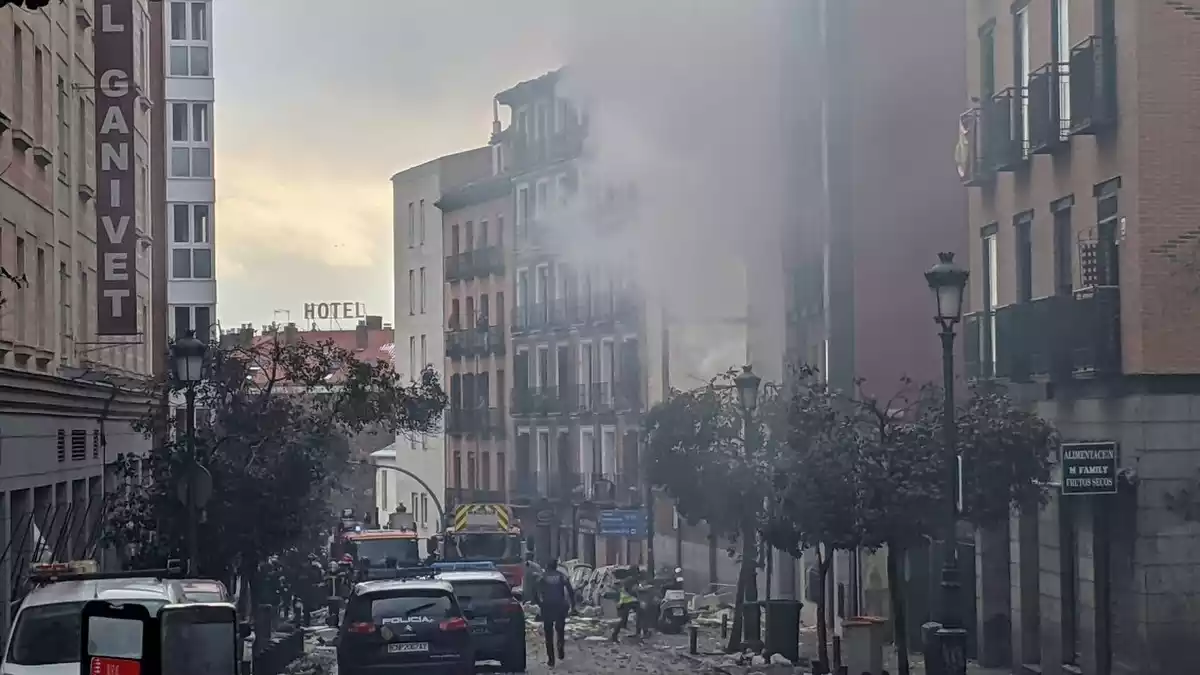 Fotografía de la gran explosión en Madrid con coches de la policía en primer plano