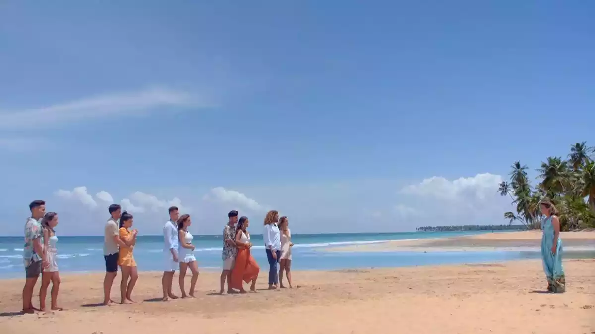 Las parejas de La Isla de las Tentaciones 3 en la playa mirando a la presentadora Sandra Barneda