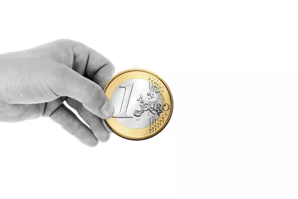 Mano con moneda de un euro