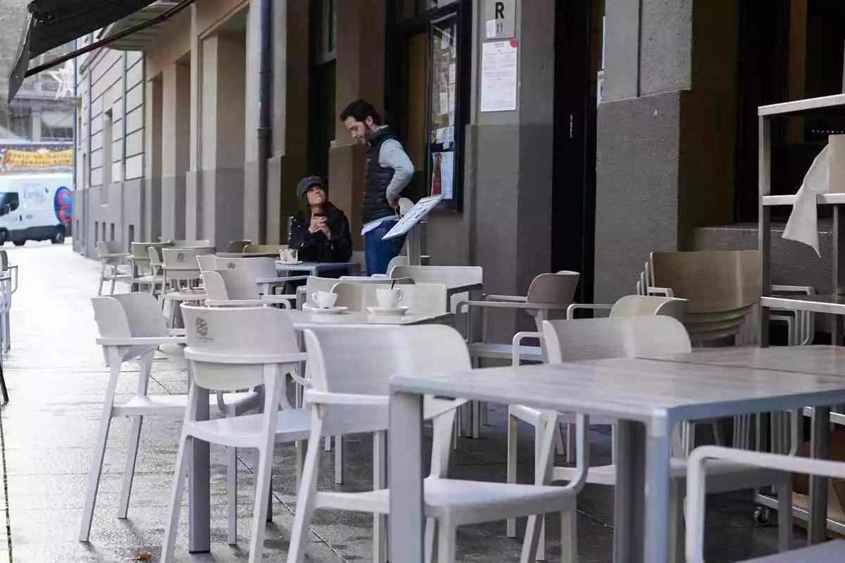 Una terraza de un bar ocupada solo por dos personas