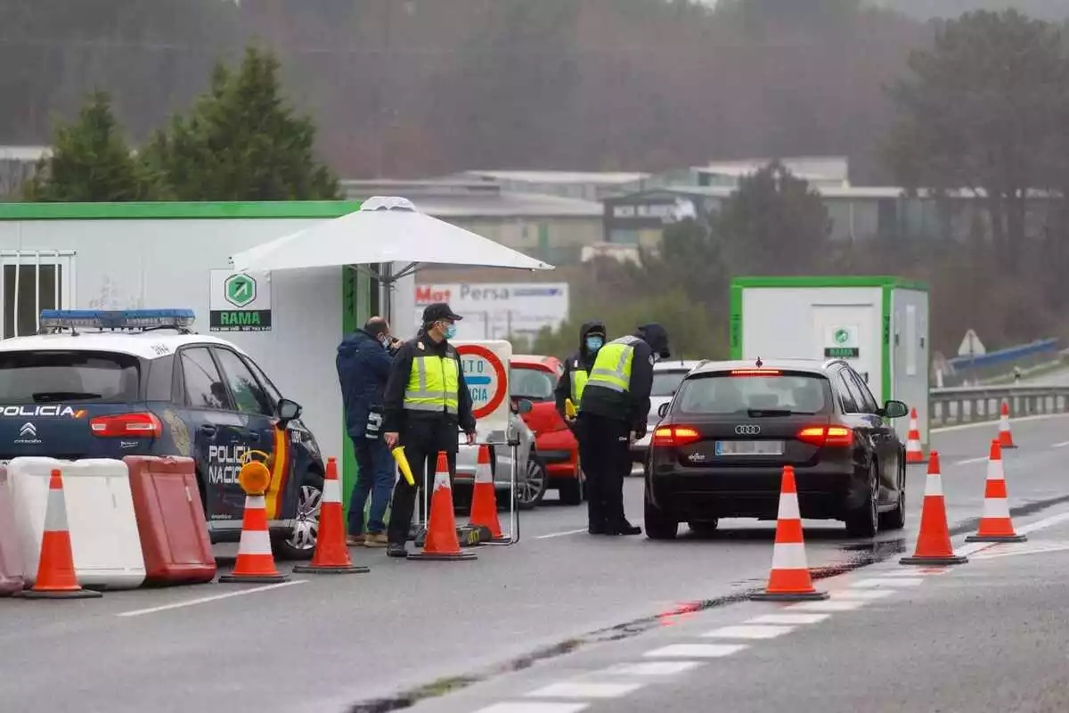 Agentes de la policía Nacional parando a un coche en un control en la frontera de Portugal