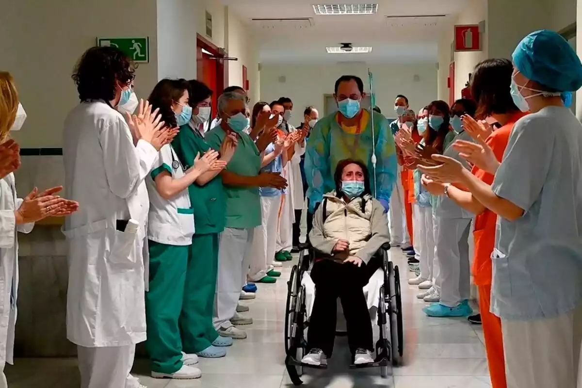 Elsa, paciente covid abandonando el hospital en silla de ruedas llevada por un médico