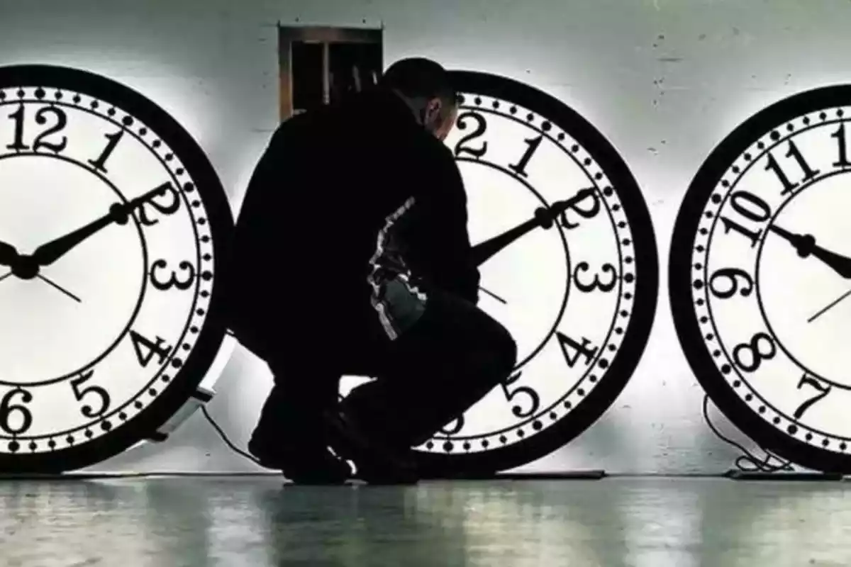 Imagen de un hombre cambiando la hora de unos relojes