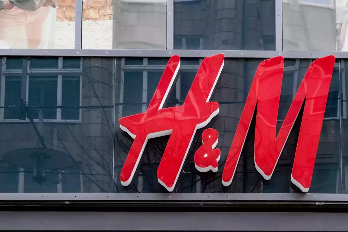 Logo de H&M en una tienda, de color rojo sobre fondo negro