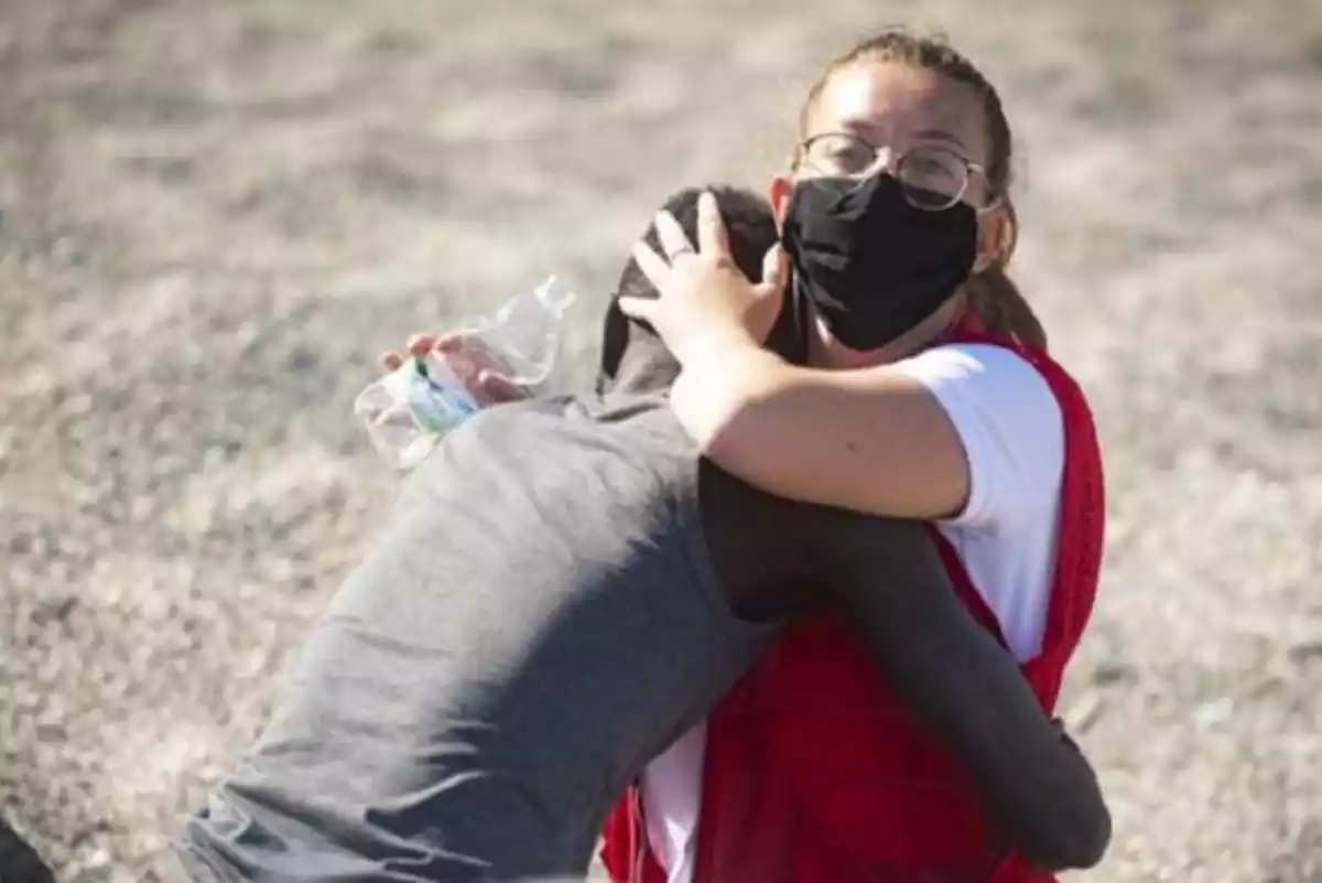 Luna Reyes, voluntaria de la Cruz Roja, abraza a un migrante recién llegado a Ceuta