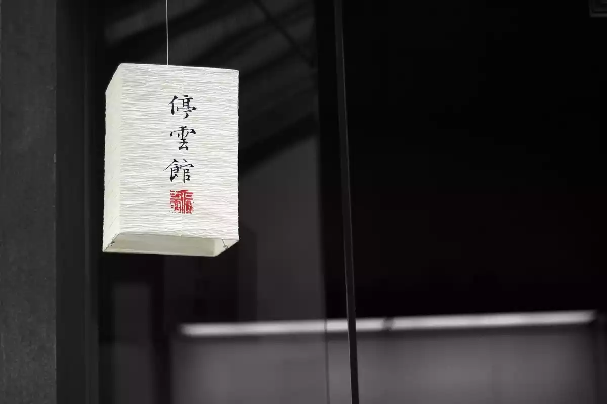 Un farol de papel de color blanco con símbolos religiosos chinos