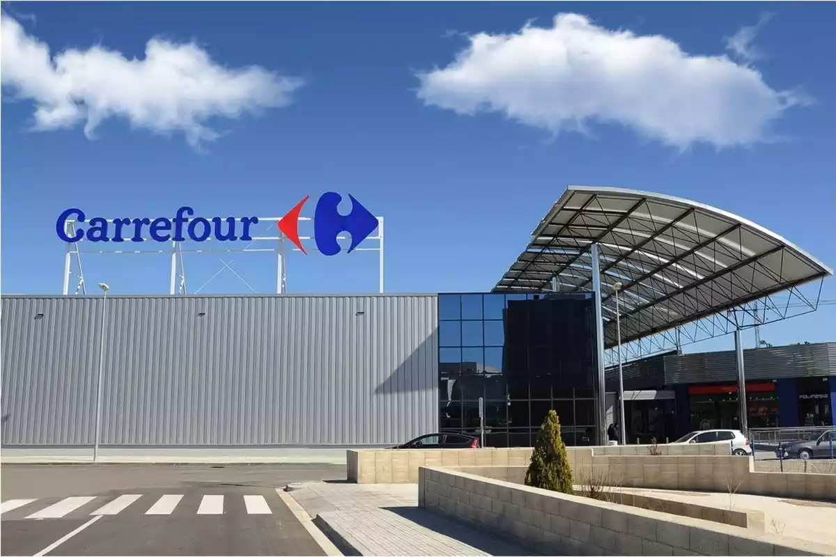 Un hipermercado de Carrefour con su logo y el aparcamiento