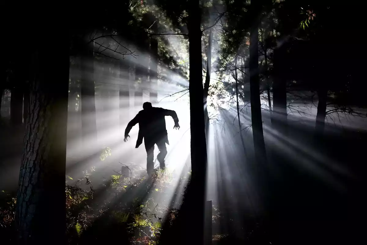 Un hombre espeluznante persiguiendo personas en el bosque