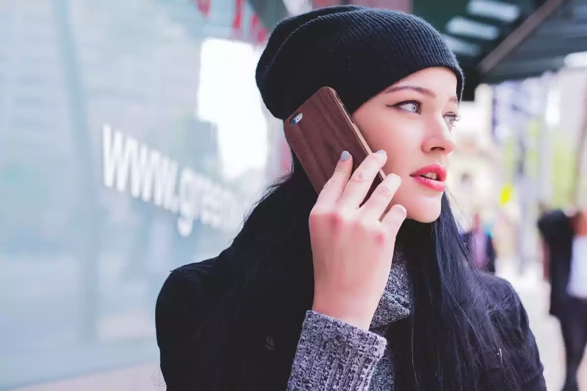 Una joven mujer hablando por teléfono en medio de la calle