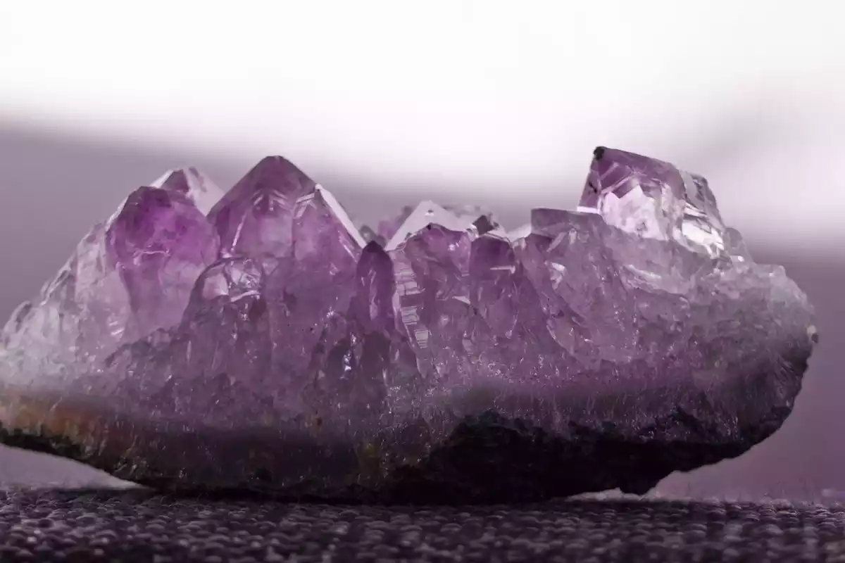 Una piedra Amatista de color violeta sobre una superficie plana