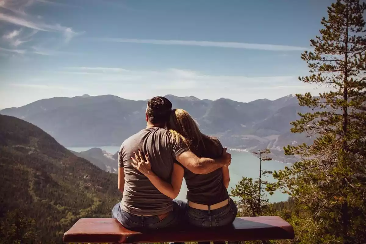 Un hombre y una mujer abrazados en la montaña