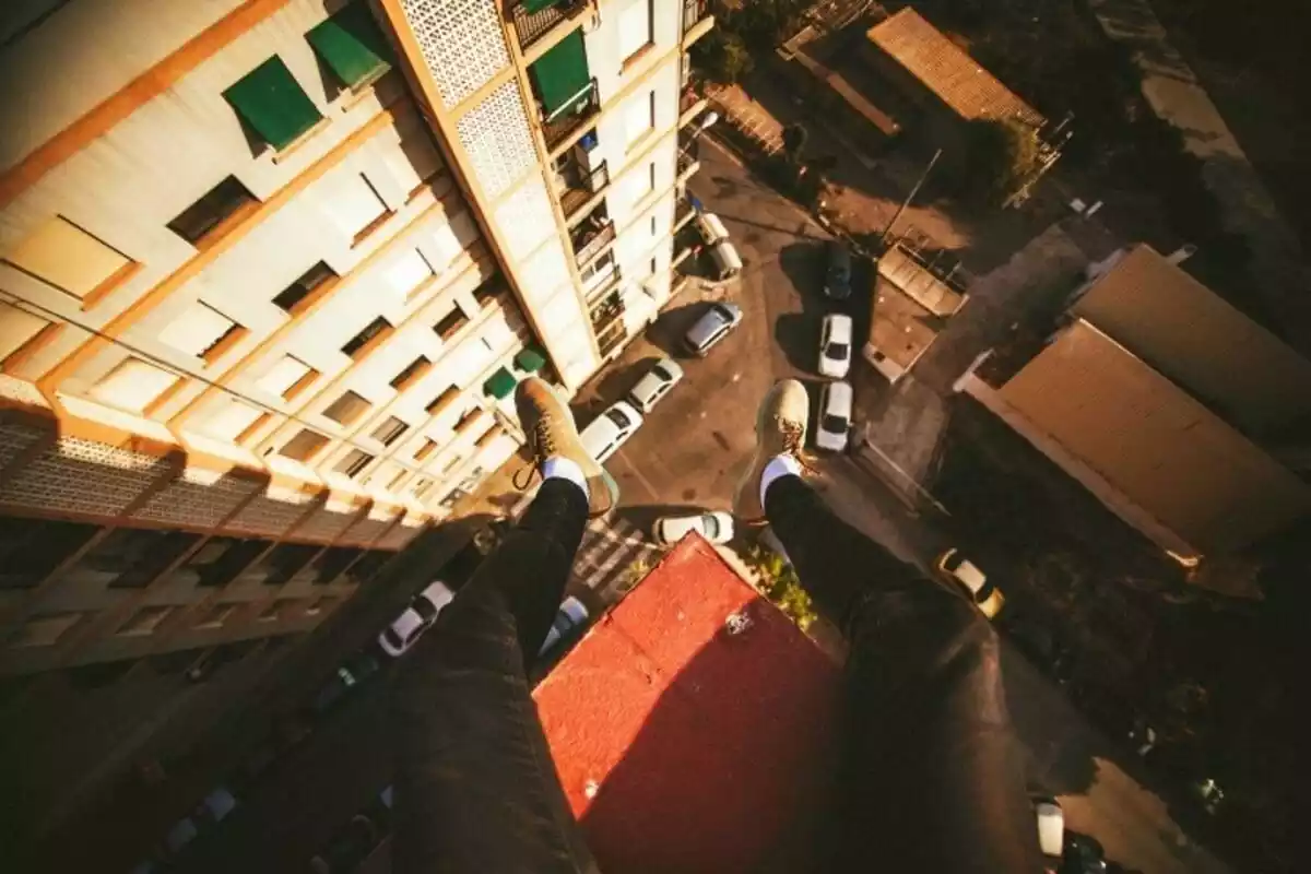 Foto de piernas en lo alto de un edificio