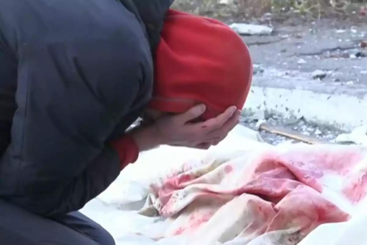 Un hombre llora ante el cadáver de su madre en Kiev
