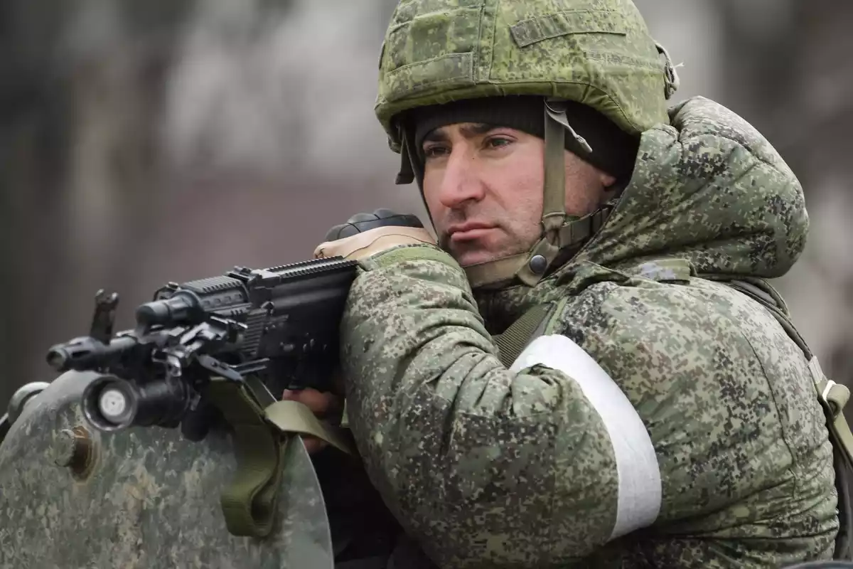 Un soldado con un arma en la mano y mirando fijamente