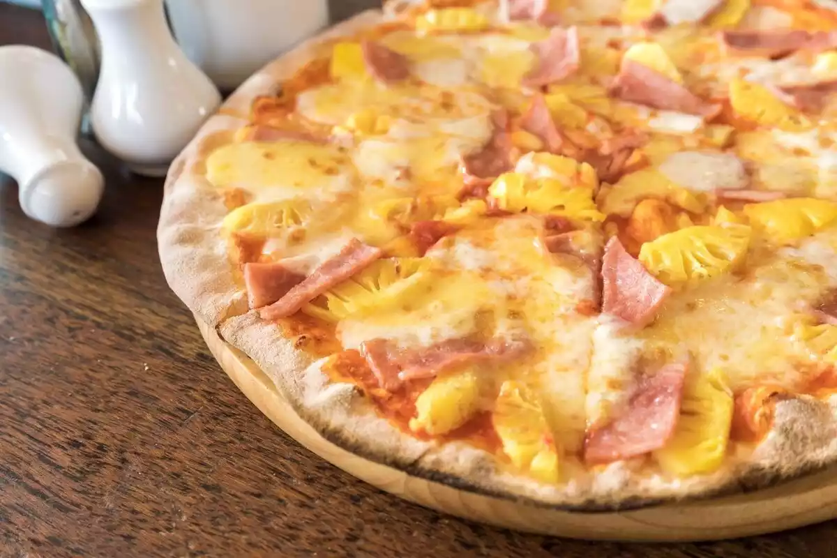 Una pizza de jamón y piña