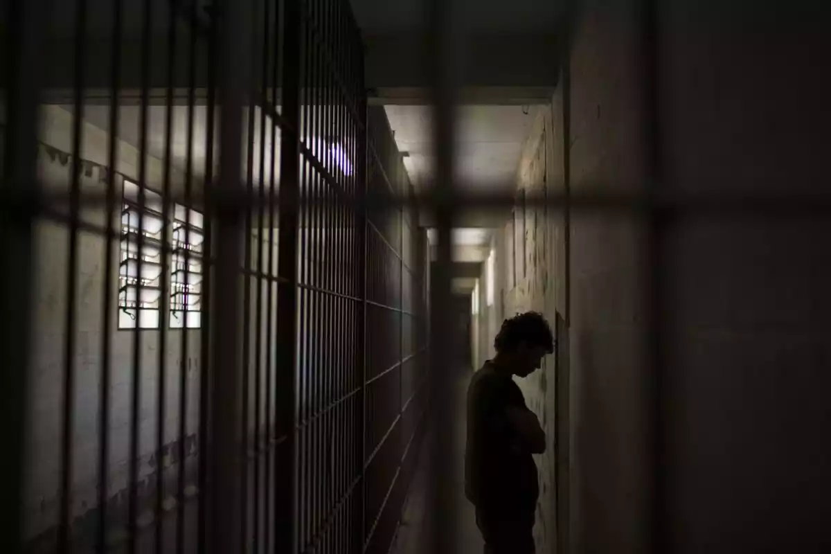 Interior de una cárcel con la silueta de un preso dentro