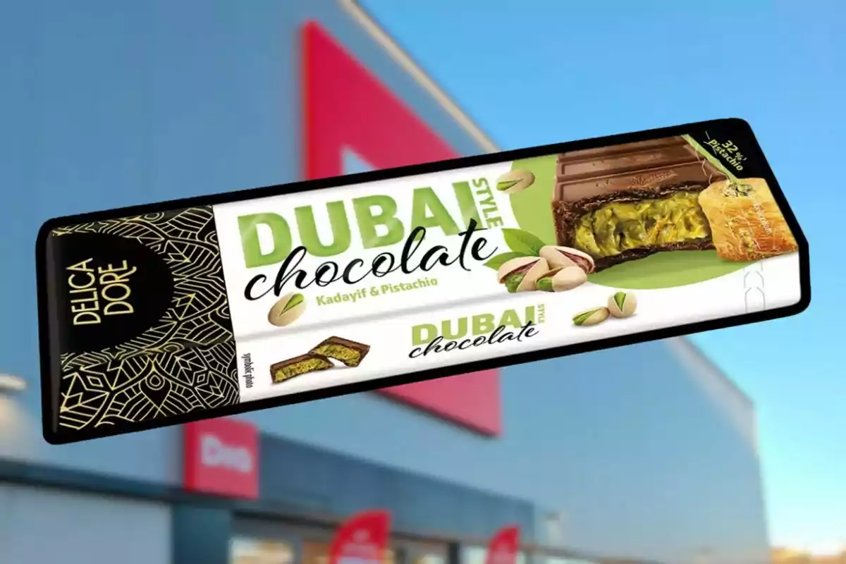 A Dubai-style chocolate bar with kadaif and pistachio flavor from the brand Delica Dore, set against a blue sky background and a blurry building. A Dubai-style chocolate bar with kadaif and pistachio flavor from the brand Delica Dore, set against a blue sky background and a blurry building.
