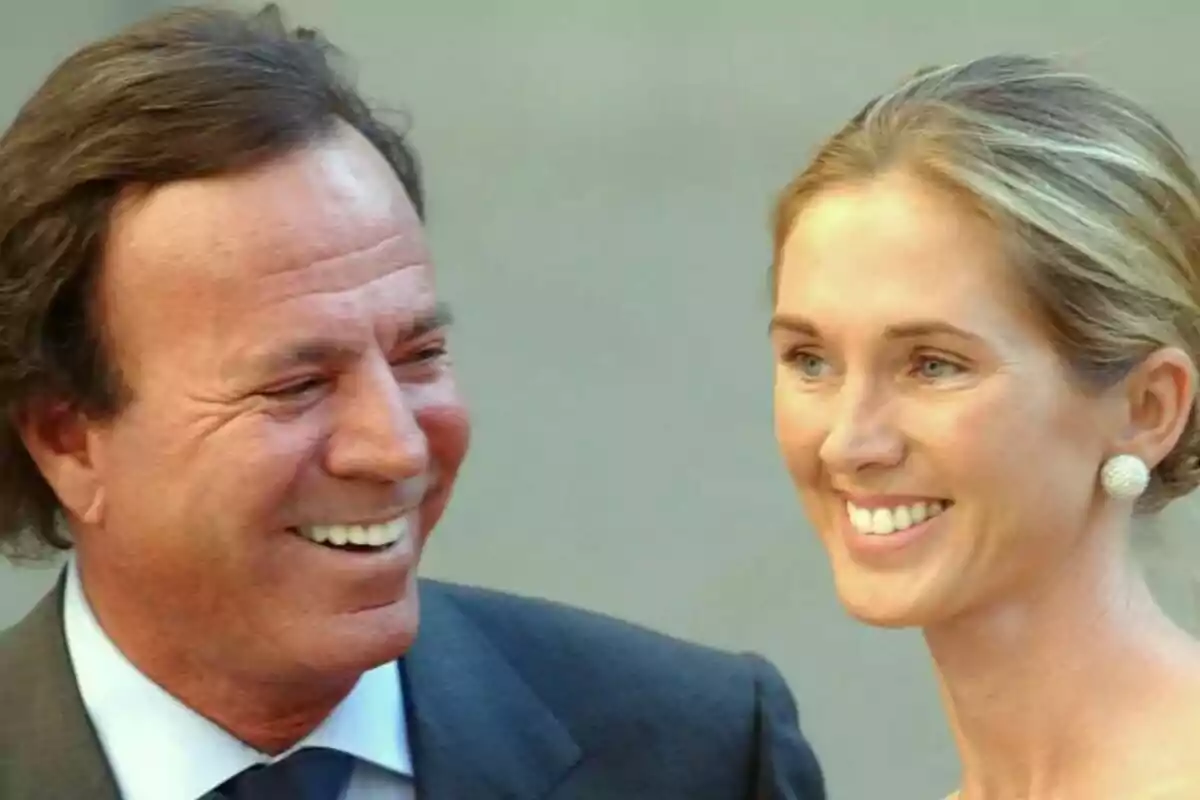 Julio Iglesias y Miranda Rijnburger sonriente, Julio con traje y corbata y Miranda con aretes grandes y el cabello recogido.