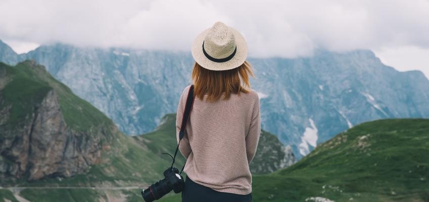Imagen de una mujer de espaldas contemplando un paisaje de montaña