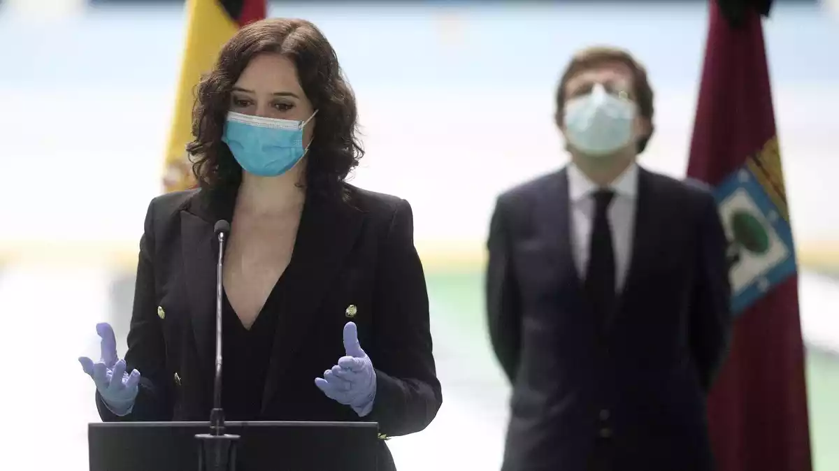 La presidenta de la Comunitat de Madrid, Isabel Díaz Ayuso, amb l'alcalde de Madrid, José Luis Martínez Almeida, en la clausura del Palau de Gel utilitzat com a morgue improvisada durant la pandèmia de coronavirus, el 22 d'abril de 2020